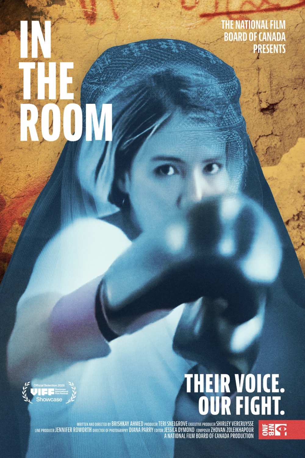 A poster for the film In the Room shows a person with a draped, semi-transparent blue fabric covering the head and upper body. The person’s arm is raised, with a gloved hand extending forward. The background is a textured golden-brown surface resembling painted or distressed material. Large white text on the left reads “IN THE ROOM.” At the top right, smaller white text reads “THE NATIONAL FILM BOARD OF CANADA PRESENTS.” At the bottom right, bold white text reads “THEIR VOICE. OUR FIGHT.” Film credits appear along the bottom edge, along with a logo in the lower-right corner and a festival laurel in the lower-left corner.